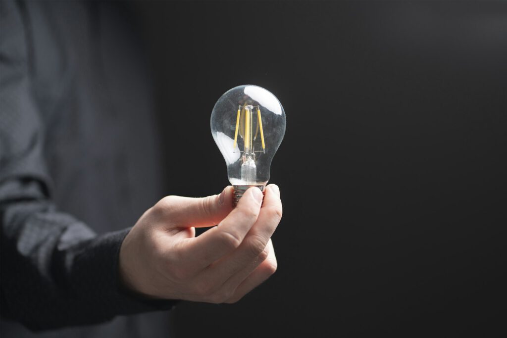 a businessman holds a light bulb as the symbol of new idea or solution